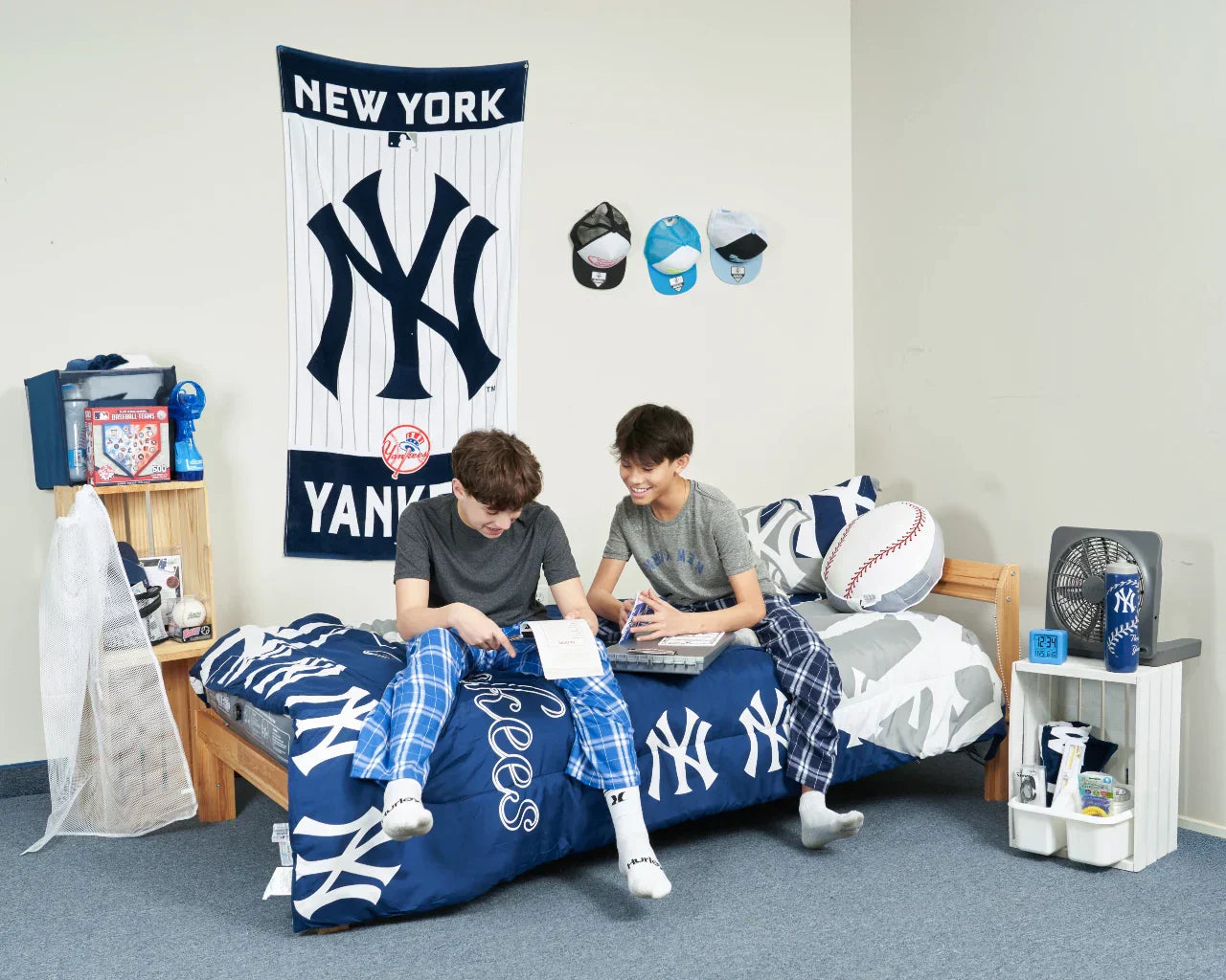 two boys sitting on camp bed set decorated with personalized items