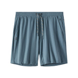 A pair of slate blue athletic shorts with an elastic waistband, a matching drawstring, and side pockets, shown against a plain white background.