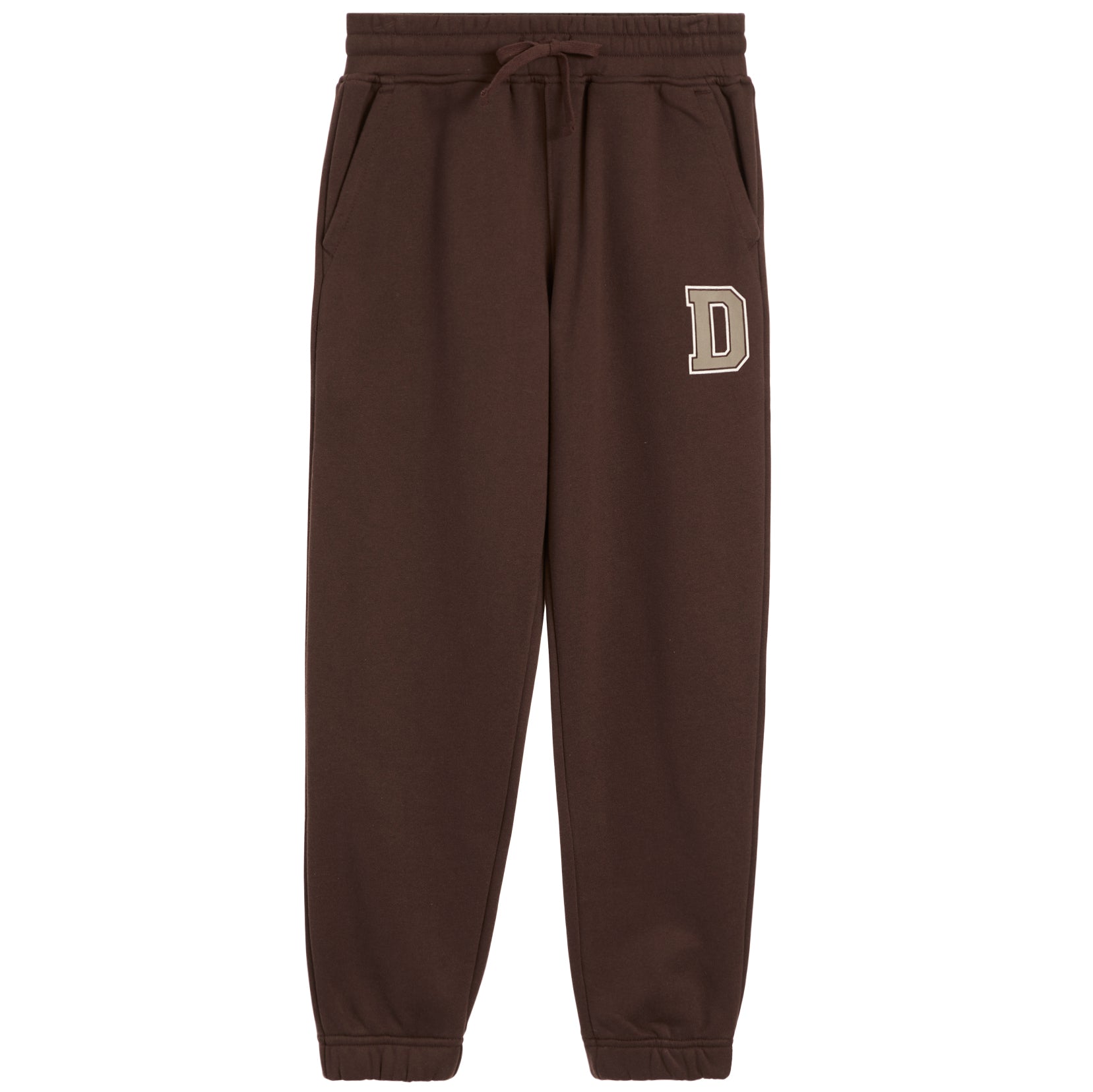 A pair of dark brown sweatpants with an elastic drawstring waist and side pockets, featuring a beige block letter 'D' on the left thigh, shown against a plain white background.