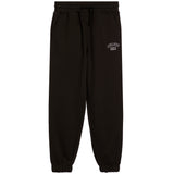 Black sweatpants with an elastic waistband, drawstring, side pockets, and elastic cuffs, featuring a small white graphic on the upper left thigh.
