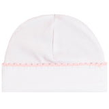 A white knit baby beanie hat featuring a delicate light pink braided trim along the folded cuff.