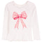 A white long-sleeve top with a large pink floral bow graphic on the front, small rhinestone embellishments around the neckline, and ruffled trim at the hem.