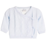A white knit baby cardigan with a crossover V-neck, cable knit pattern, and three light blue buttons, shown on a plain white background.