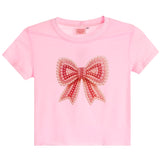 A light pink short-sleeve crop top featuring a large, decorative pearl-embellished bow on the front, displayed against a solid white background.