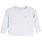 A light blue long-sleeve crewneck sweatshirt for a baby or toddler, featuring a small embroidered smiley face patch on the left chest.