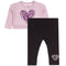 A toddler girl's two-piece outfit set featuring a light pink long-sleeve top with a purple glitter heart graphic on the front, paired with black leggings that have a small white glitter heart on the lower leg.