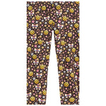 A pair of children's leggings featuring a dense all-over pattern of yellow smiley faces, pink bows, and small multicolored flowers on a dark brown background.