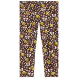 A pair of children's leggings featuring a dense all-over pattern of yellow smiley faces, pink bows, and small multicolored flowers on a dark brown background.