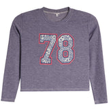A kids' long-sleeve crop top in heathered periwinkle purple, featuring a large '78' graphic on the chest with a blue paisley pattern and a red outline.
