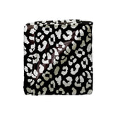A folded blanket featuring a black and white leopard print pattern, shown against a plain white background.