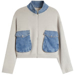 A light beige knit sweater with a contrasting blue denim mock neck collar and a matching frayed hem, shown a white background.