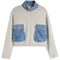 A light beige knit sweater with a contrasting blue denim mock neck collar and a matching frayed hem, shown a white background.