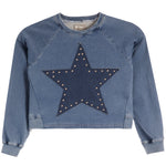 A cropped blue denim sweatshirt featuring a large dark blue star patch on the front, embellished with small gold-tone studs, shown against a plain white background.