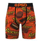 A pair of men's boxer briefs featuring an all-over Reese's Peanut Butter Cups print on a bright orange background, with a black waistband and drawstring.