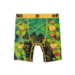 Boy's boxer briefs featuring a colorful graphic print of the Teenage Mutant Ninja Turtles on a black and green cityscape background, with a yellow waistband.
