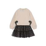 A children's long-sleeve dress with a cream-colored knit top and a black tiered tulle skirt with small bow details, shown on a plain white background.