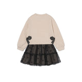 A children's long-sleeve dress shown from the back, featuring a beige sweatshirt-style upper body with black ribbon accents at the waist and a black tulle tutu skirt with small black bow details.