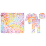 A children's tie-dye clothing set laid out on a white background, including a large square blanket, a short-sleeve wrap-style top, matching pants, and a beanie. The fabric has a pastel rainbow tie-dye pattern with pink, yellow, blue, orange, and purple tones.