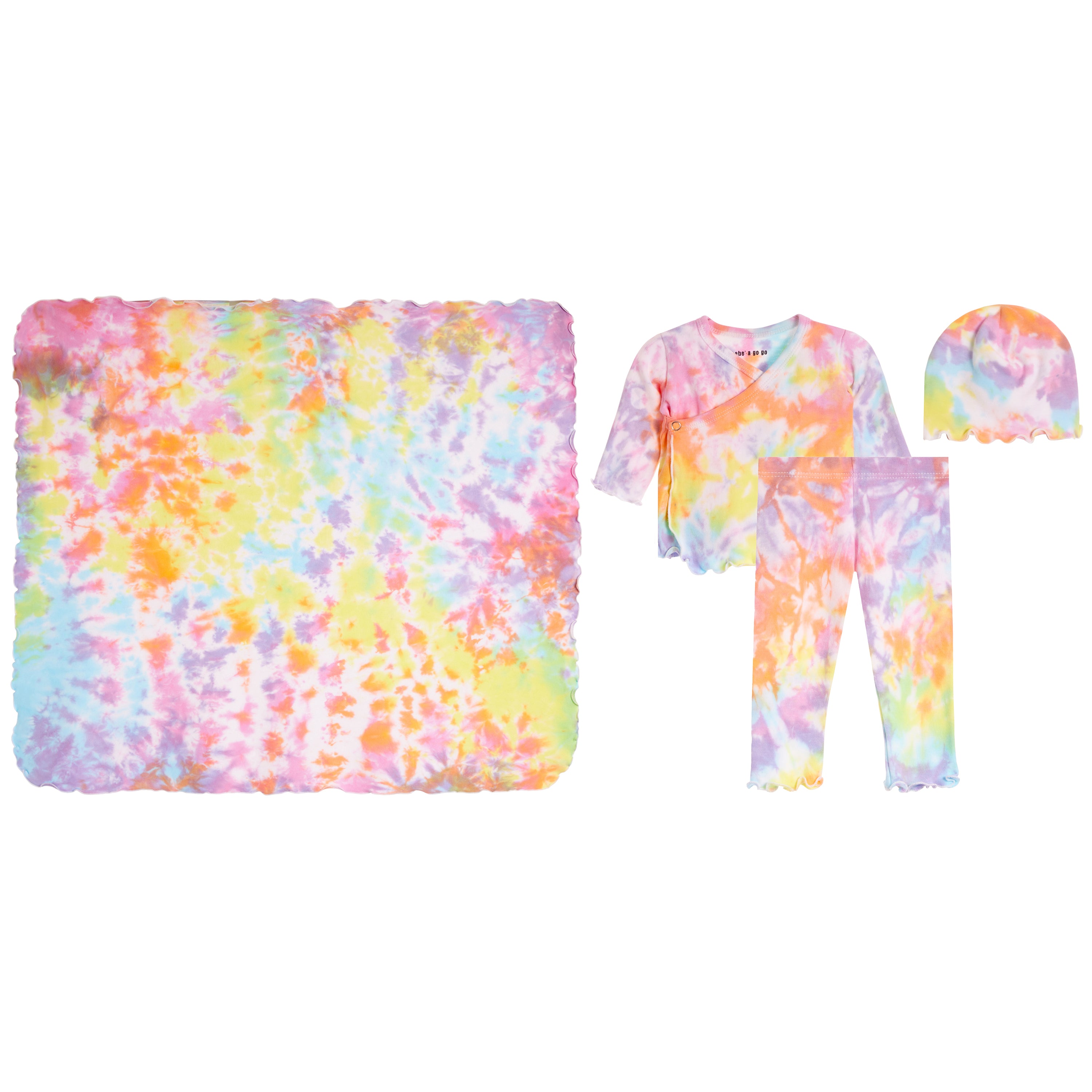 A children's tie-dye clothing set laid out on a white background, including a large square blanket, a short-sleeve wrap-style top, matching pants, and a beanie. The fabric has a pastel rainbow tie-dye pattern with pink, yellow, blue, orange, and purple tones.