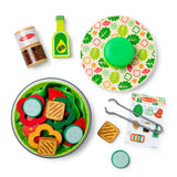 Colorful toy food set with a bowl, plates, and utensils on a white background