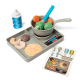 Toy kitchen set with pan, tray, and toy food items on a white background