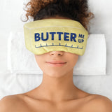 Person wearing a yellow sleep mask with 'Butter Me Up' text on a white background