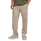 A person wearing beige Under Armour jogger sweatpants, an olive green t-shirt, and beige running shoes, shown from the waist down on a white background.