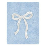 A square light blue fuzzy blanket or throw featuring a large white faux-pearl bow applique in the center, shown against a plain white background.