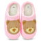 Pair of pink slippers with bear face design on a white background