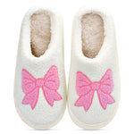 White slippers with pink bows on a white background