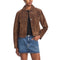 A woman wearing a brown suede jacket over a black top and a blue denim mini skirt, photographed against a plain white studio background.