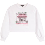 A white cropped sweatshirt with a pink and black line-art graphic of a bakery storefront on the chest, with the words 'FRESHLY BAKED' printed below the illustration.