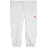 Light heather gray sweatpants with an elastic waistband and cuffs, featuring a small red Jumpman logo on the left hip.