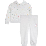A children's two-piece athletic loungewear set by Jordan, featuring a light heather gray hoodie with a small multicolor Jumpman and number '23' print, paired with matching light heather gray jogger pants with a red Jumpman logo on the left thigh.