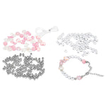 A jewelry-making bead kit with various beads, including pink and white flower-shaped beads, clear rhinestone beads, silver ball beads, and white thread, arranged on a plain white background.