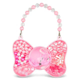 A pink beaded bow-shaped purse charm with compartments filled with pink and white beads, faux pearls, rhinestones, and tinsel, suspended from a matching beaded strap on a white background.