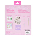 Back of a gingerbread house craft kit package in pink, showing included items such as stickers, wooden gingerbread house pieces, paintbrush, and printed instructions in English and French.