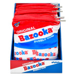 A retail display box filled with red, white, and blue Bazooka Bubble Gum plush bag toys, with metal spring clips attached along the top edges.