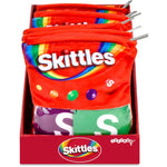 A retail display box filled with red plush pouches designed to look like Skittles candy bags, with visible metal zipper pulls and multiple Skittles branding panels on the front.