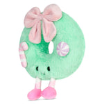 A mint green plush donut toy with a large pink bow, pink and white striped candy accents, and pink feet, shown on a plain white background.