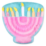 A plush toy menorah with a light blue body, pink arched inner lining, and nine colorful candle shapes with yellow flames, shown on a plain white background.