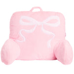 A pink plush baby support pillow shaped like a gift box with a white embroidered bow on the front, set against a plain white background.