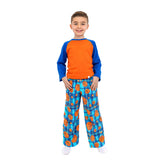 A young boy modeling a two-piece pajama set featuring a bright orange and blue raglan t-shirt and matching blue plaid pants with an orange basketball pattern, set against a plain white background.
