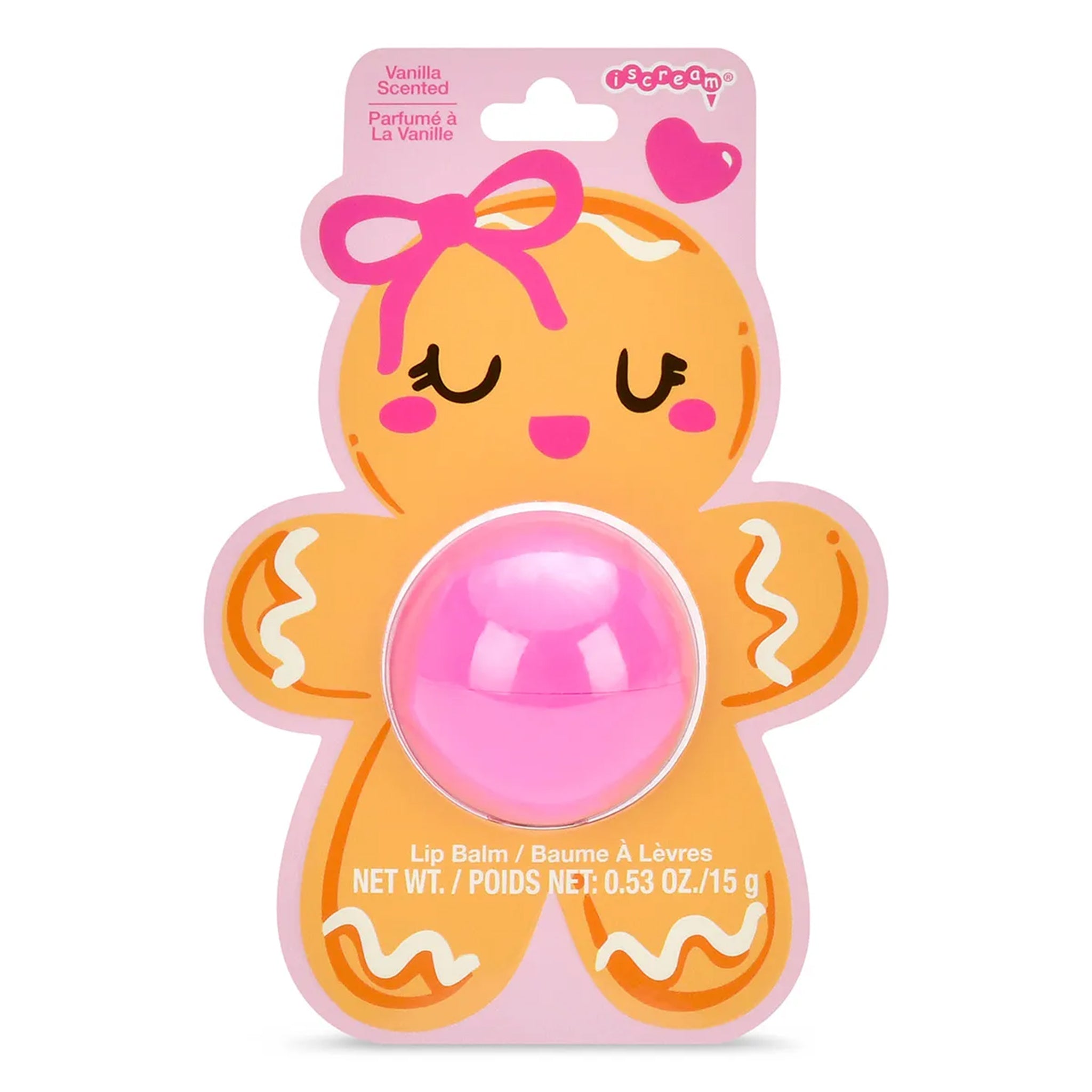 A packaged lip balm shaped like a smiling gingerbread cookie, with a pink oval balm container in the center and a card backing showing vanilla scent text and a pink heart logo.