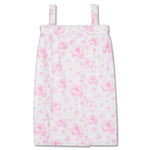 A white spa wrap with a pink floral pattern, featuring thin shoulder straps and a front closure, shown against a plain white background.