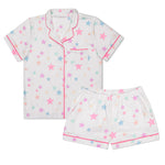 A two-piece children's pajama set featuring a short-sleeve button-front top and matching shorts in white, decorated with a pastel star pattern in pink, blue, and yellow, finished with pink piping trim.