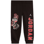 Black sweatpants featuring red and white Air Jordan graphics, including a large 'JORDAN' print down one leg, a '23' and wolf graphic on the other leg, and a white Jumpman logo near the right hip.
