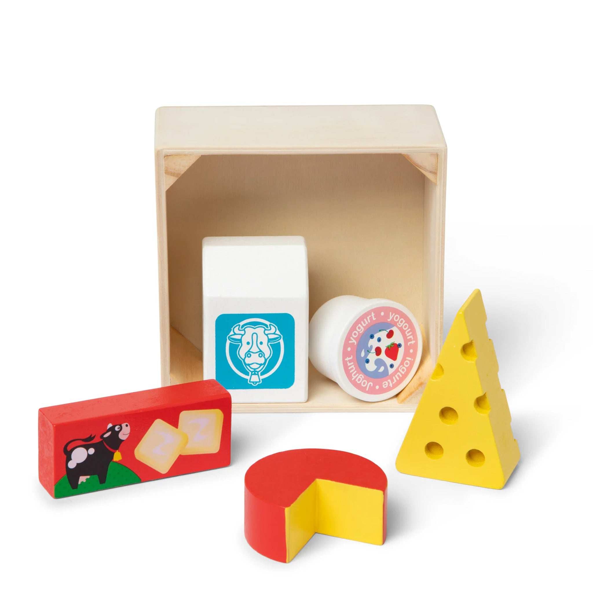 A children's wooden toy cheese set with a natural wood box, including a white block labeled cow, a round labeled milk, a red and yellow cheese wedge, a yellow cheese block, and a red box with a cow illustration.