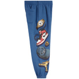 Blue sweatpants featuring a graphic print of a gold watch, a red and white sneaker, a gold ring, a blue cap, and a gold jordan logo on a white background.