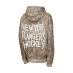 A long-sleeve hoodie shown from the back, featuring a brown and beige tree-branch camouflage pattern with 'NEW YORK RANGERS HOCKEY' printed in large white letters across the center.